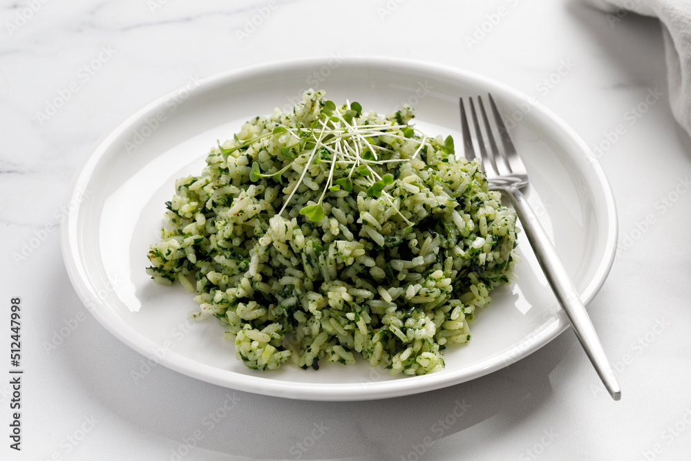 Spinach Rice with microgreens on white plate with fork on marble Background, Healthy Vegetarian diet Food. Green Rice with Spinach. Spinach Rice with microgreens on white plate with fork on marble Background, Healthy Vegetarian diet Food. Green Rice with Spinach.