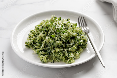 Spinach Rice with microgreens on white plate with fork on marble Background, Healthy Vegetarian diet Food. Green Rice with Spinach.