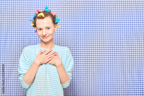 Portrait of happy young woman with colorful hair curlers on head