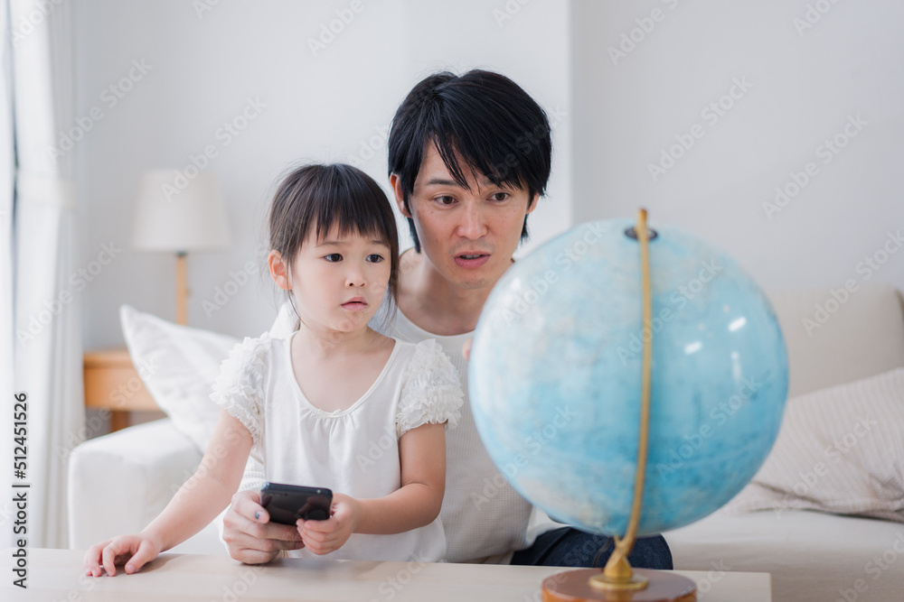 パパと地球儀を使って勉強する家族
