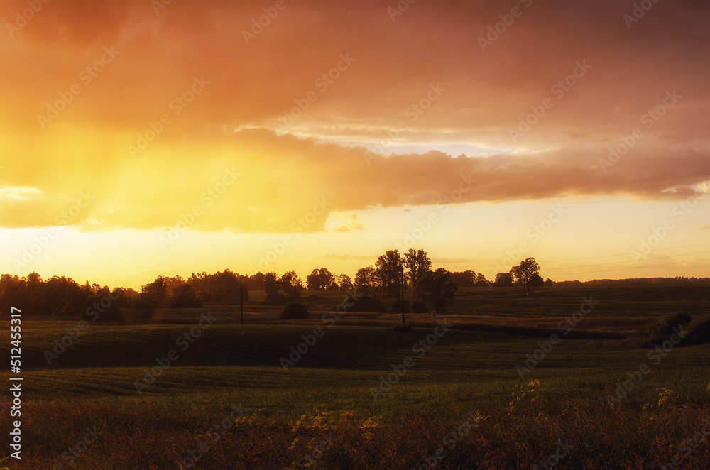 field near village with sunset