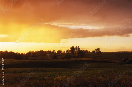 field near village with sunset