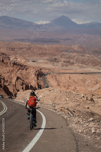 Ciclista en medio de una carretera en el desierto, Atacama, Chile.