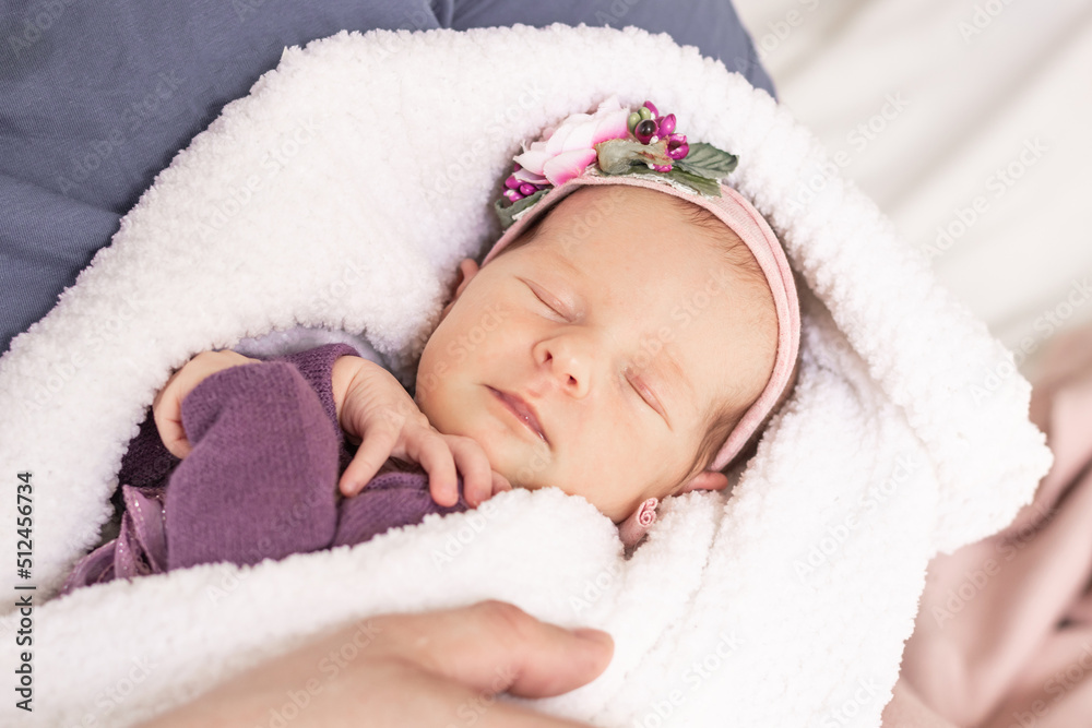 Sleeping newborn baby girl wrapped in a white fluffy blanket in the arms of the parents, first month Sleeping newborn baby girl wrapped in a white fluffy blanket in the arms of the parents, first month