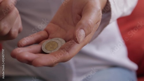 Manos de persona contando monedas mexicanas photo