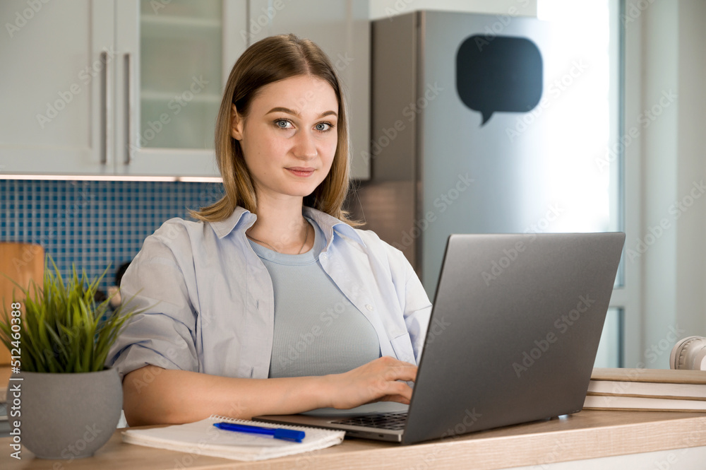 Closeup of a female student smiling and holding pen near laptop.Back to school concept Closeup of a female student smiling and holding pen near laptop.Back to school concept