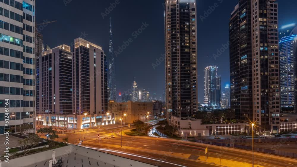 Aerial panoramic view to Dubai downtown and difc illuminated skyscrapers with busy traffic on intersection in Business bay district night timelapse. Aerial panoramic view to Dubai downtown and difc illuminated skyscrapers with busy traffic on intersection in Business bay district night timelapse.