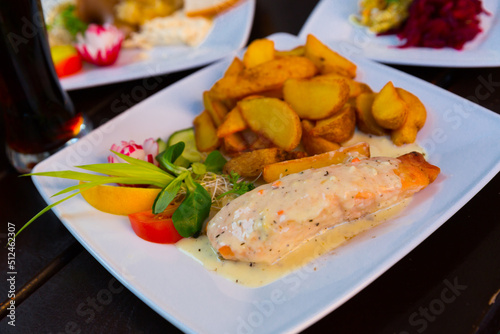 Salmon with sauce and potatoes is tasty dish in the kitchen.