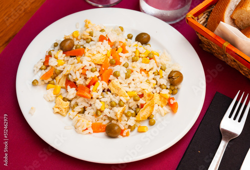 Tasty salad with rice, scrambled egg, corn, green peas, carrot and olives