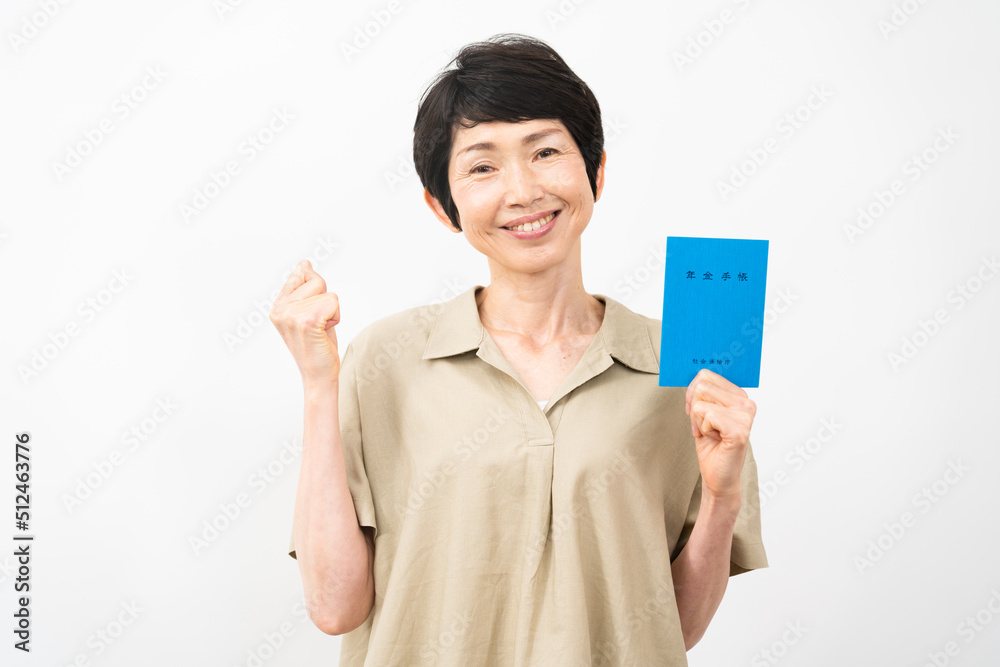 年金手帳を持ってガッツポーズをするミドル女性 年金手帳を持ってガッツポーズをするミドル女性