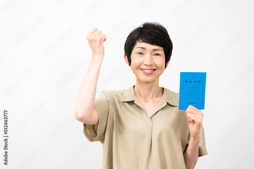 年金手帳を持ってガッツポーズをするミドル女性 年金手帳を持ってガッツポーズをするミドル女性