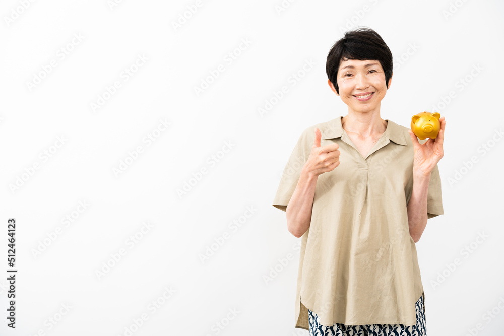 ブタの貯金箱を持ってサムズアップをするミドル女性 ブタの貯金箱を持ってサムズアップをするミドル女性