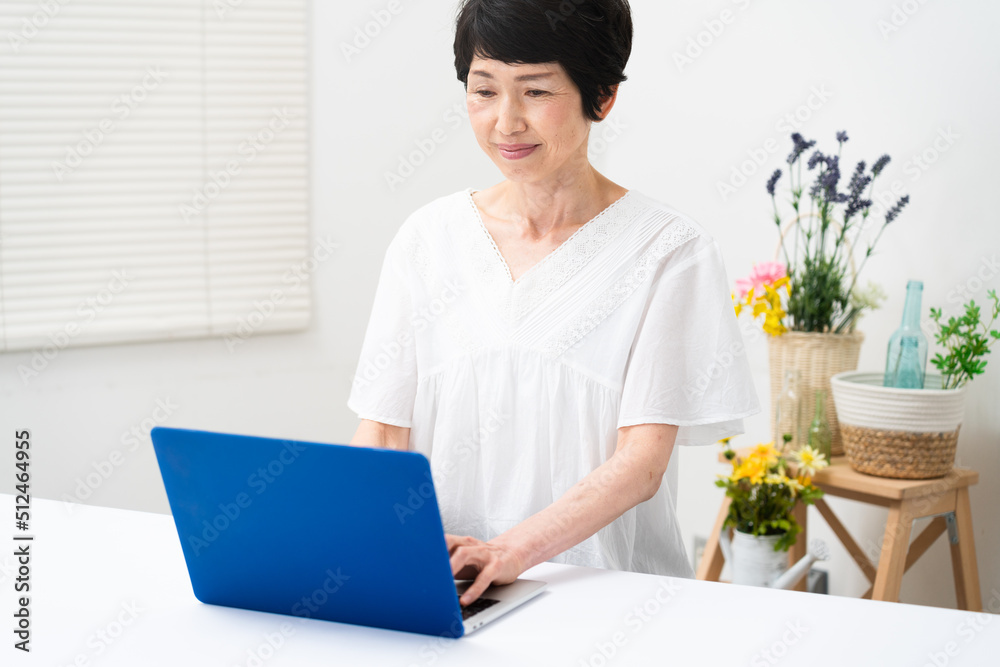 ノートパソコンを操作するミドル女性