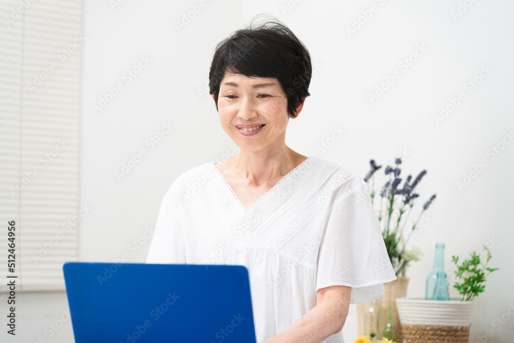 ノートパソコンを操作するミドル女性