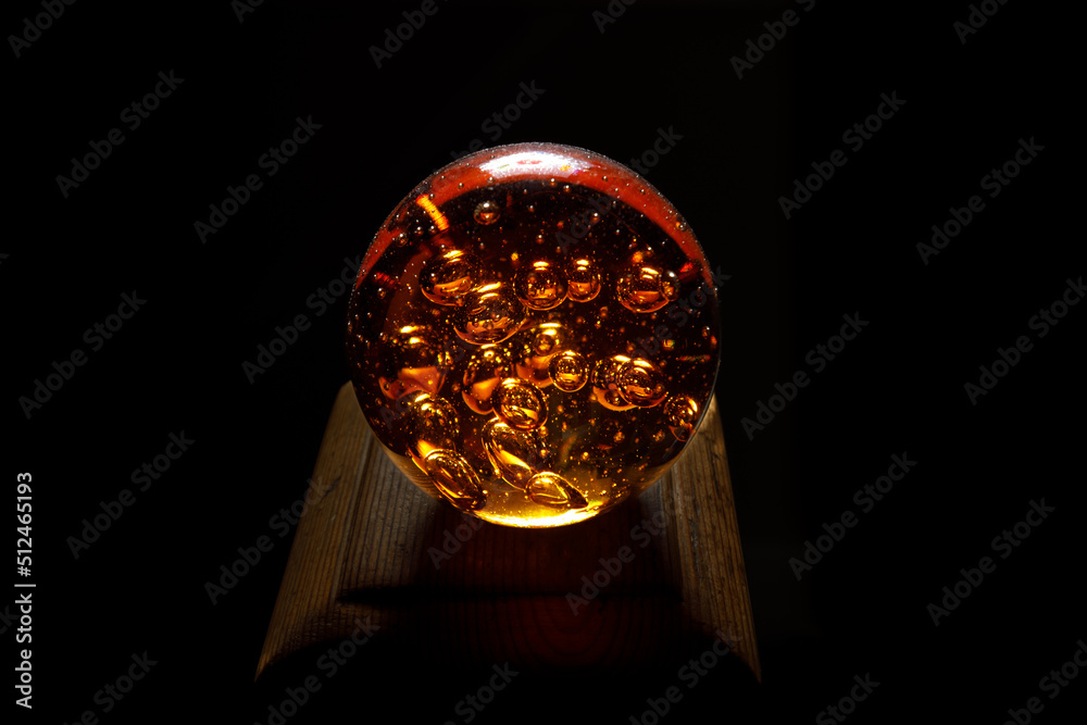 crystal ball with air bubbles inside on black background