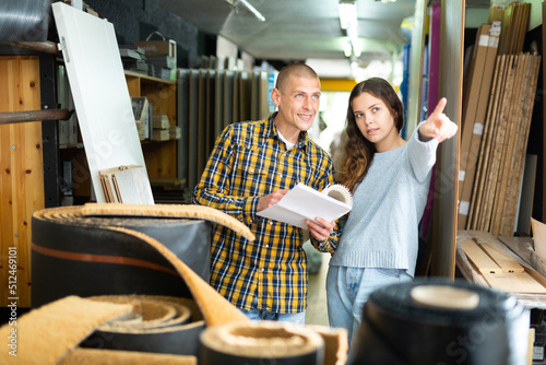 Seller points with his hand to something in the hardware store