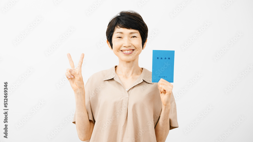 年金手帳を持ってピースサインをするミドル女性