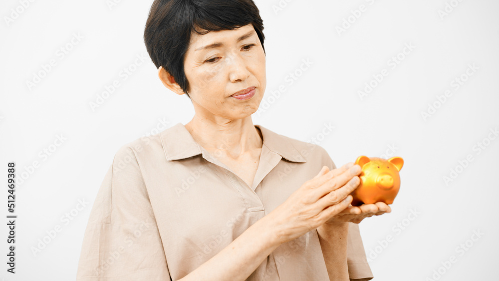 ブタの拠金箱を持って悩むミドル女性