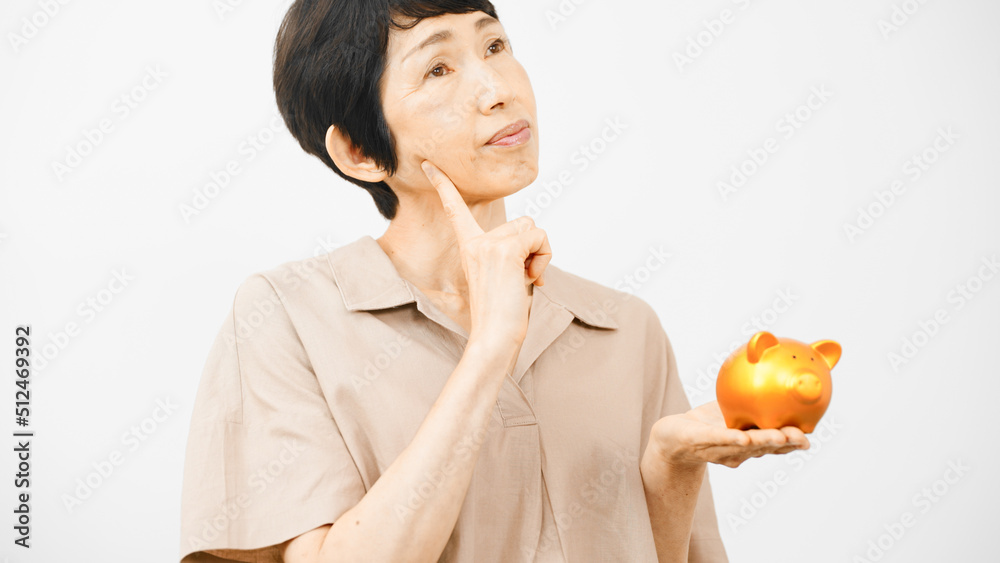 ブタの拠金箱を持って悩むミドル女性