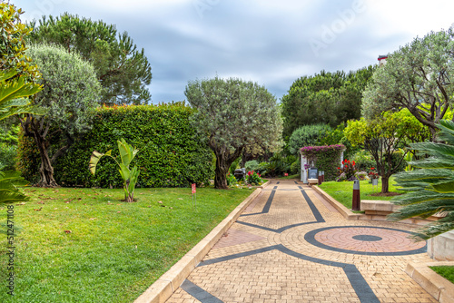 The tiled path and topiaries at the entrance to the Unesco Garden overlooking Fontvieille Harbor in Monte Carlo, Monaco. photo