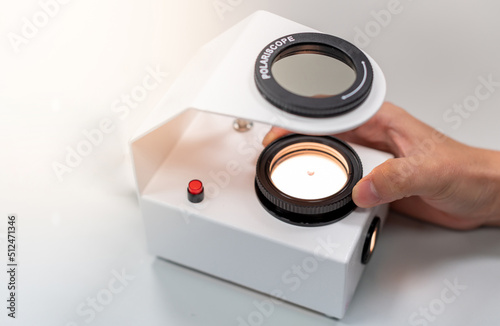 The Gemologist's expertise in her laboratory fix the value of precious stone of the polariscope.