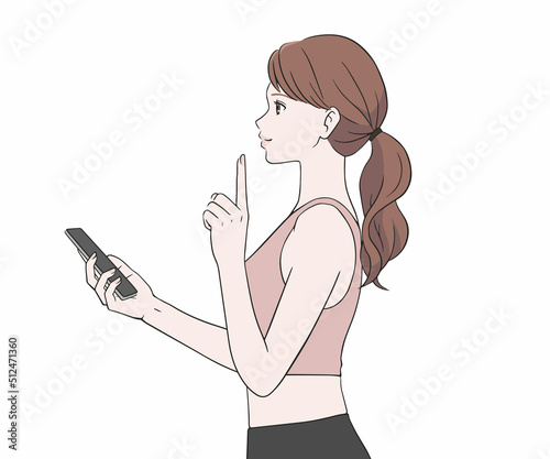 スマホを持ち指を差すスポーツインストラクター