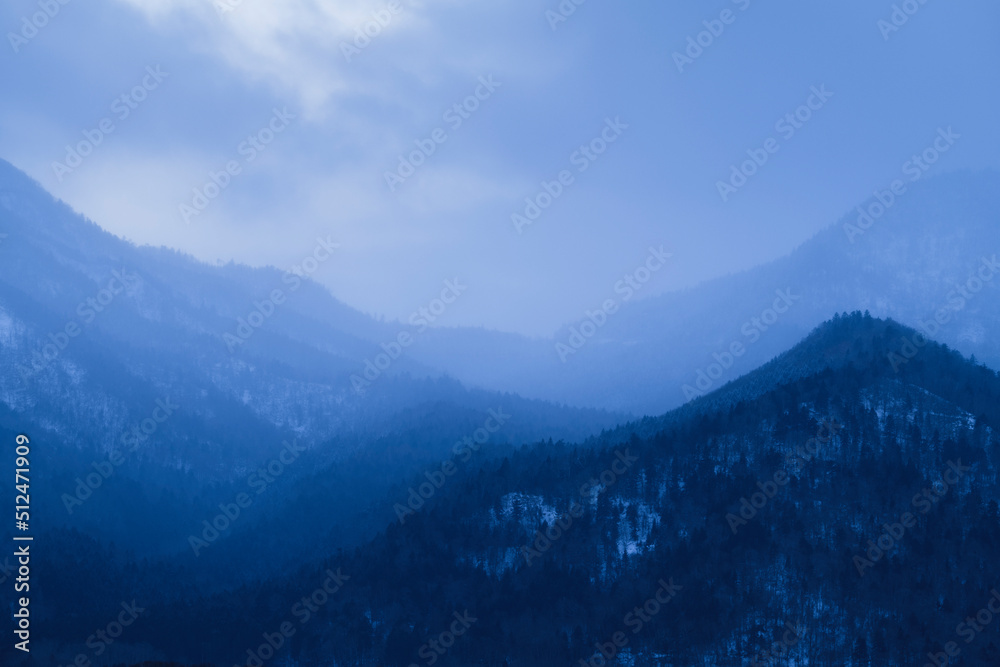 Moody view of distant mountains in the mist, Hokkaido, Japan Moody view of distant mountains in the mist, Hokkaido, Japan