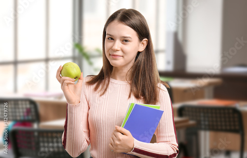 Female student with apple in classroom