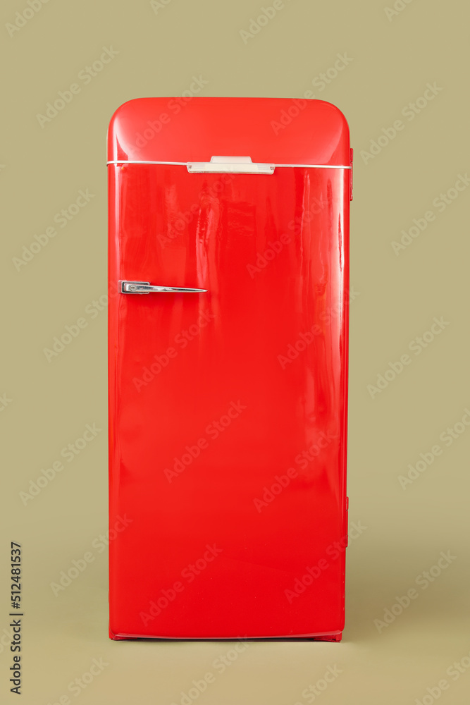 Stylish retro fridge on green background Stylish retro fridge on green background