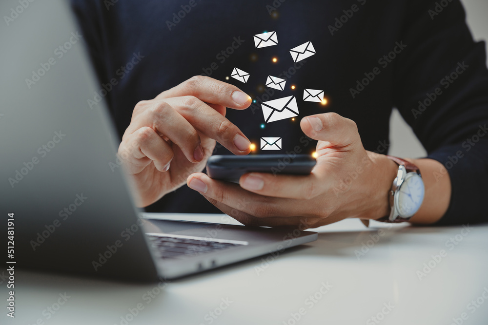 Naklejka premium Hand of businessman using smartphone with e-mail icon.