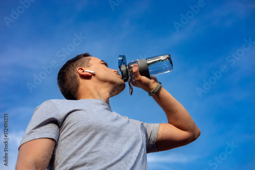 man drinking water while exercising