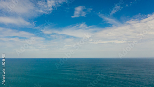 Aerial view of Blue sea with waves and sky with clouds. Ocean skyline.