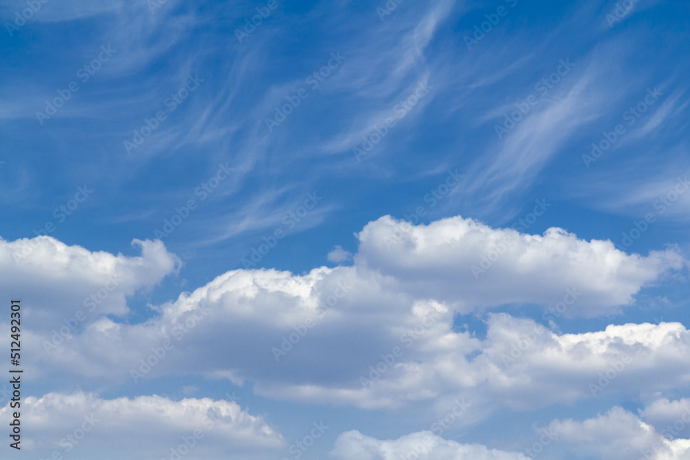 Obraz premium The background is in the form of two different types of natural clouds against the background of a blue sky.