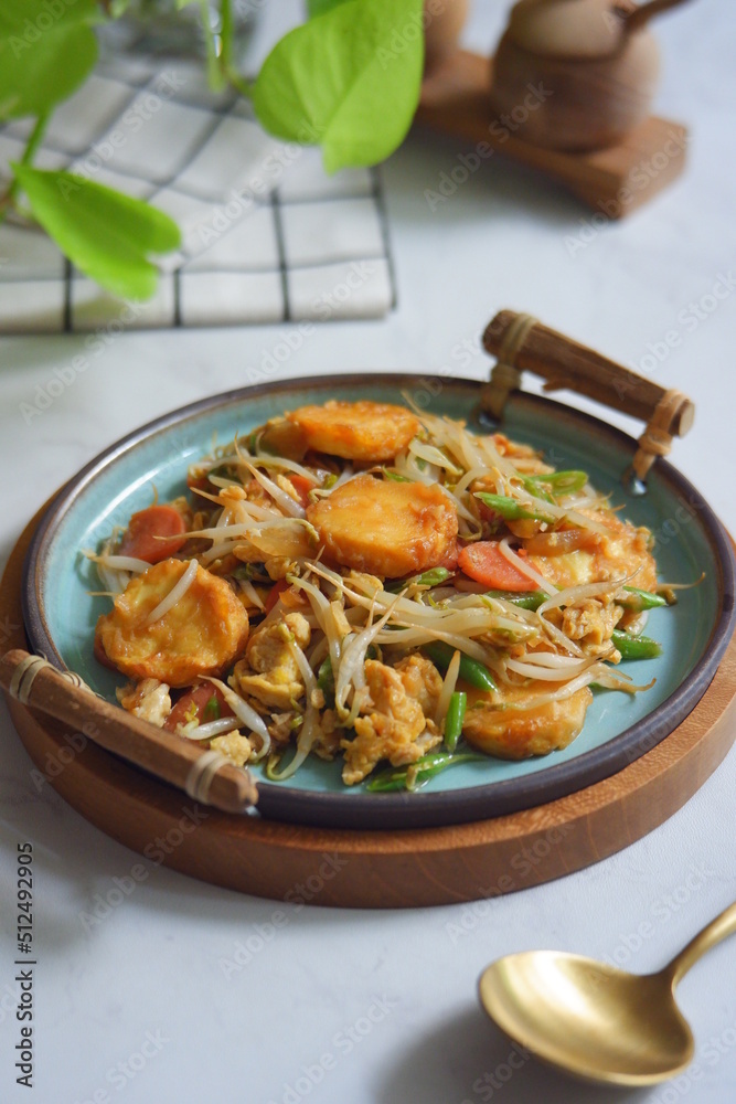a plate of stir fry tofu with vegetables 