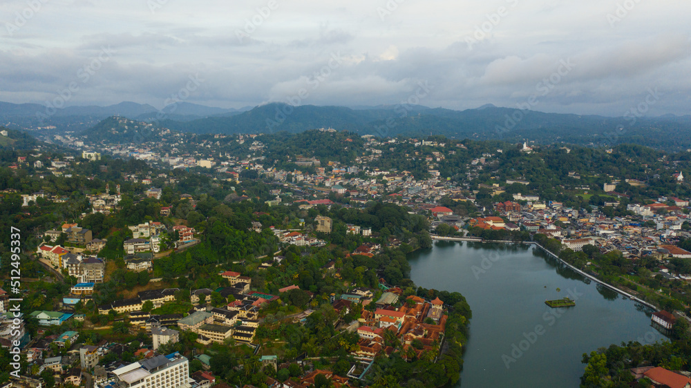 The city of Kandy is located among the mountain peaks with a tropical forest.