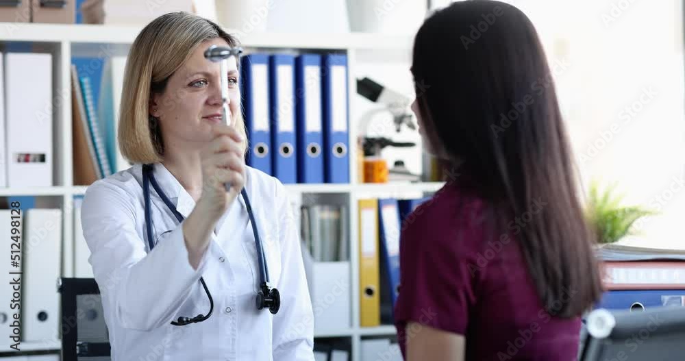 Neurologist checks nerve reflexes with hammer of patient eyes Neurologist checks nerve reflexes with hammer of patient eyes