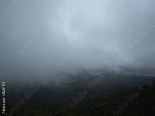 Mountain engulf with dark fog-like clouds
