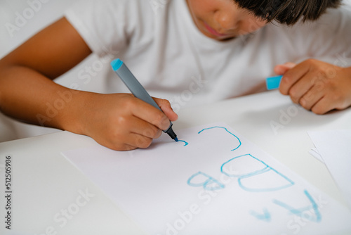 Preschooler boy writing letters