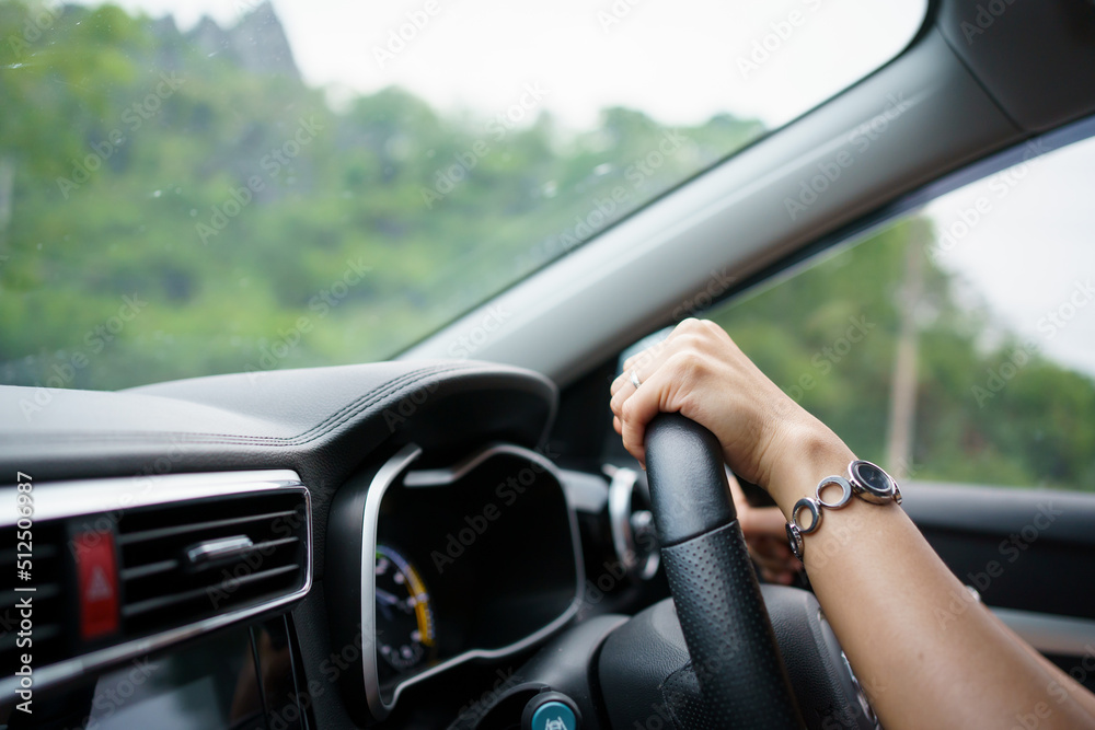 Woman driving a modern electric car EV in beautiful sunlight on the road. Safety driving concept.