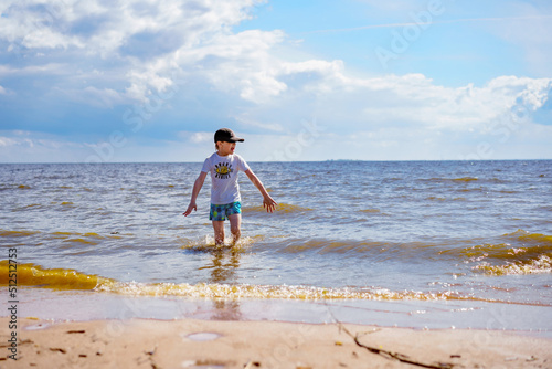  little boy feeling cold in the sea on sunny summer day.