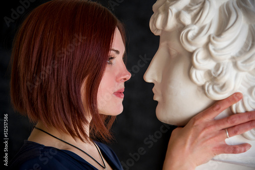 portrait of beautiful woman with bust monument of  on black background. legends of ancient greece. statue of dionysus photo