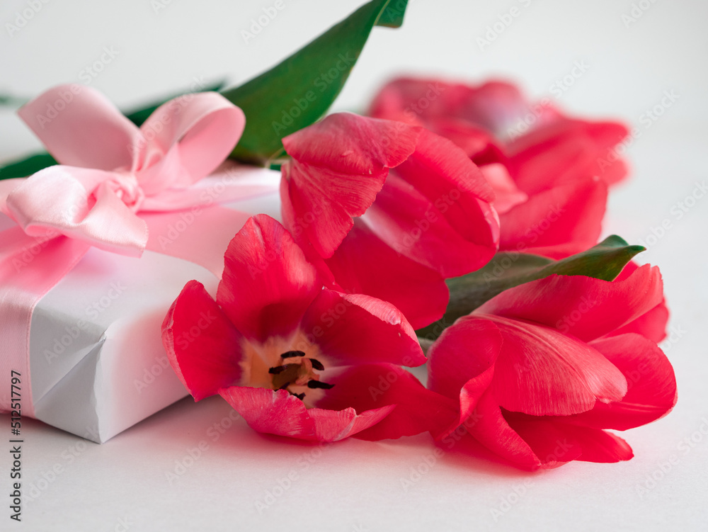 Beautiful delicate flowers with a gift box and a satin ribbon bow. Flower card, women's Day Beautiful delicate flowers with a gift box and a satin ribbon bow. Flower card, women's Day