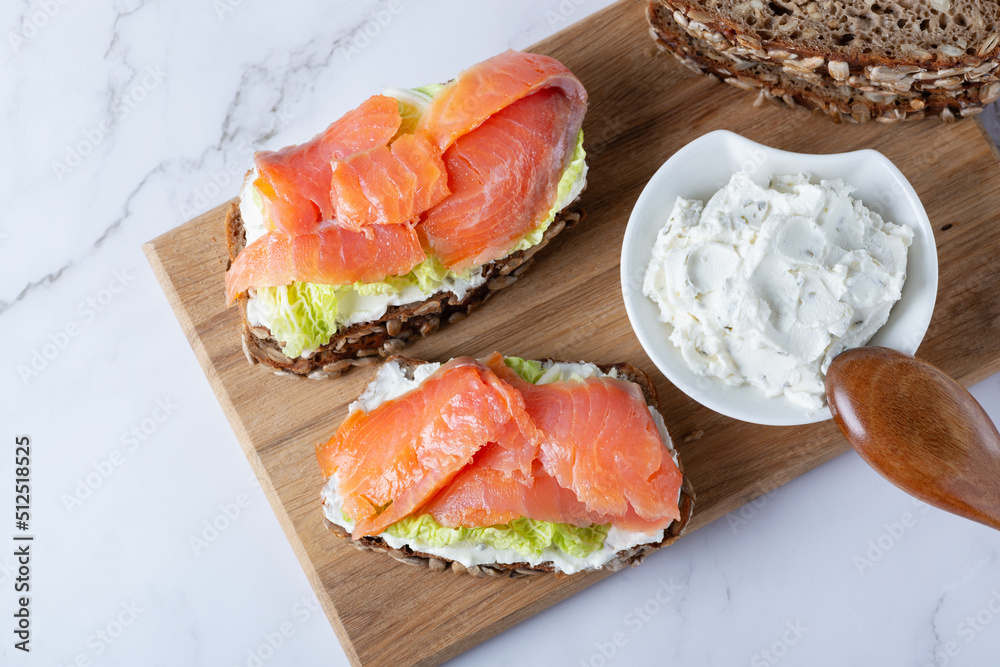 Healthy toasts with rye bread with cream cheese, salmon and salad.