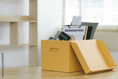 Resignation.Letter of resignation and cardboard box on the desk. Concept of termination of employment and resignation. Quitting a job, The big quit. The great Resignation. photo
