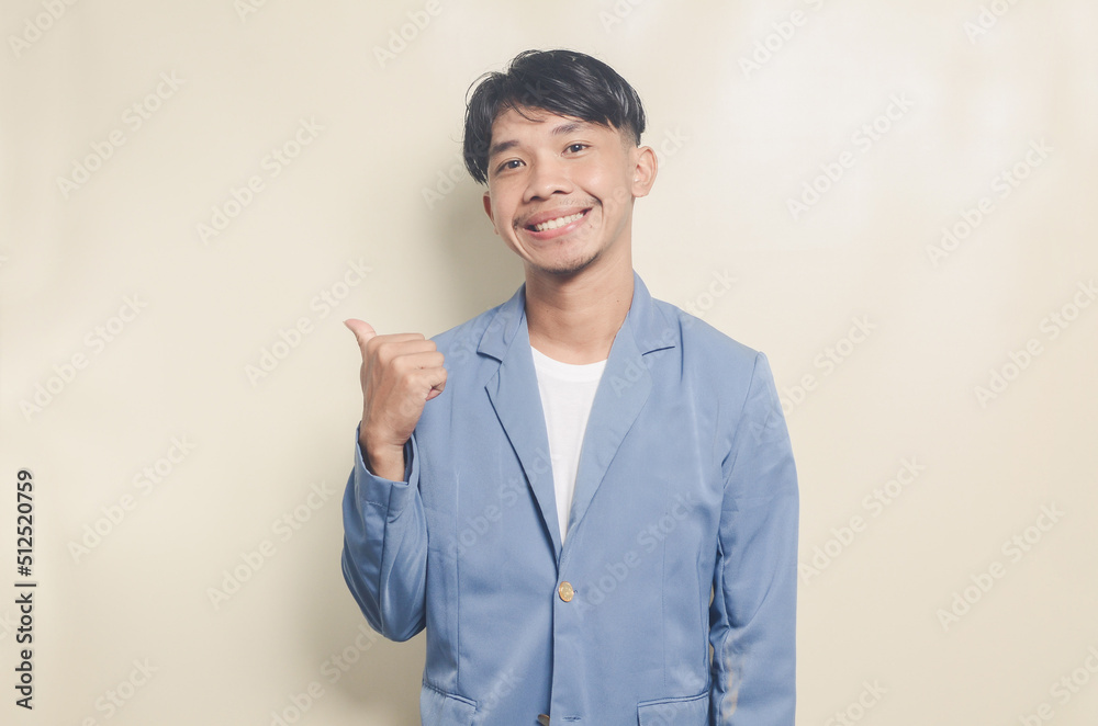 young asian man wearing college suit pointing to empty space on isolated background young asian man wearing college suit pointing to empty space on isolated background