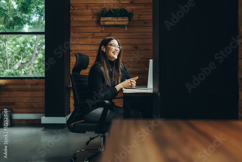 Smiling female entrepreneur having a video call in a coworking space photo