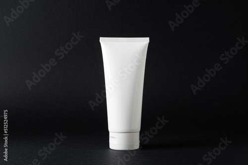 White plastic tube of cream  moisturizer on a black background