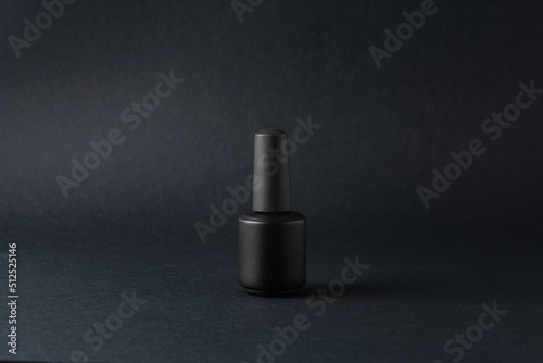 Black jar of nail polish on a black background