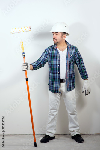Male builder in a hard hat holding a paint roller