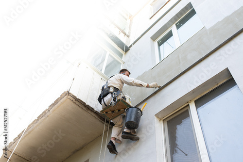 builder climber repairs the facade of the building